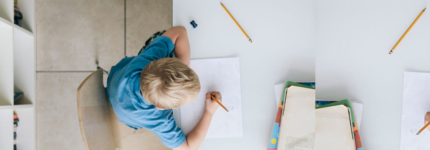 Top view image of a boy doing homework